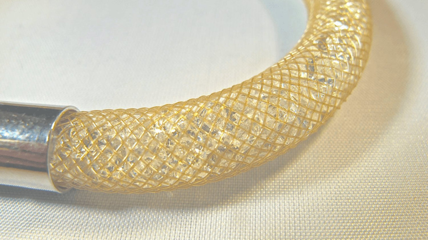 Gold colored bracelet filled with white crystals