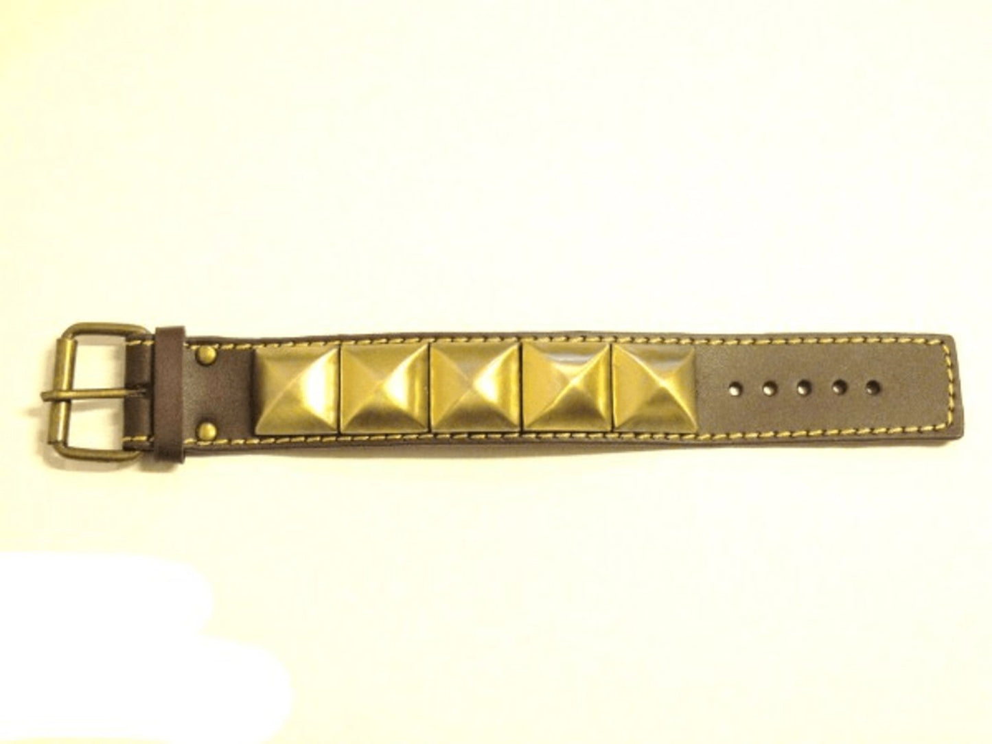 Brown leather bracelet with gold-colored pyramid rivets