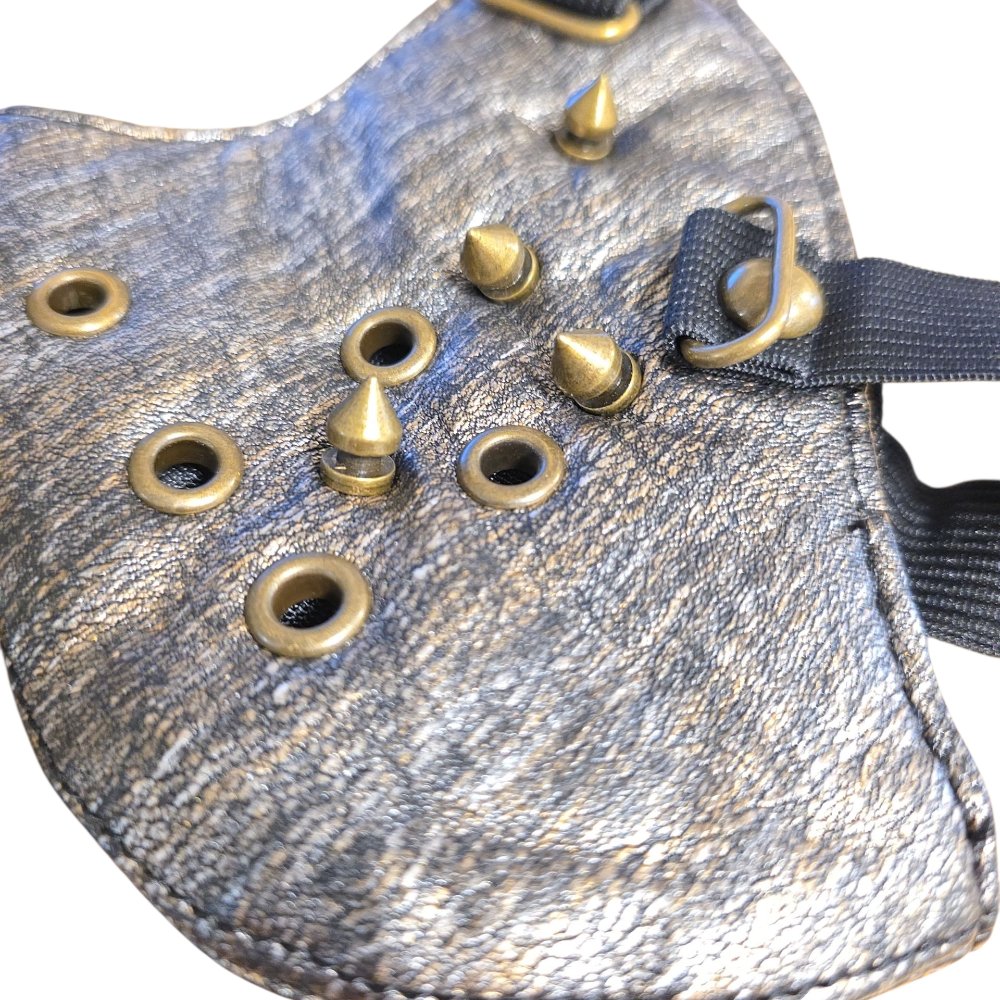 Grå ansiktsmask i konstläder med bronsfärgade spikes & öljetter
