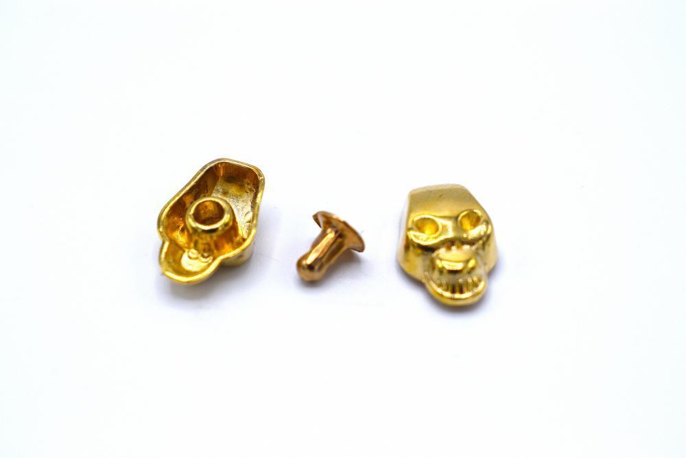 Gold colored loose rivets skulls - 50 pieces