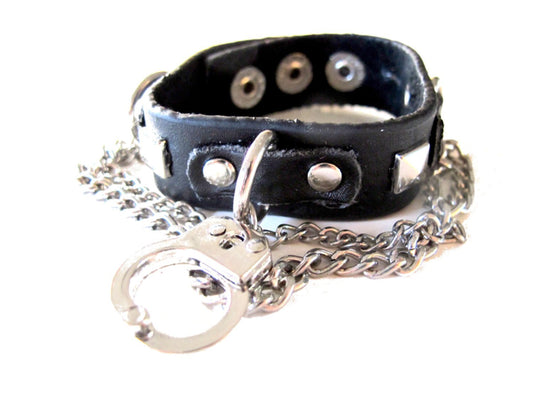 Svart armband med nitar och handklovar